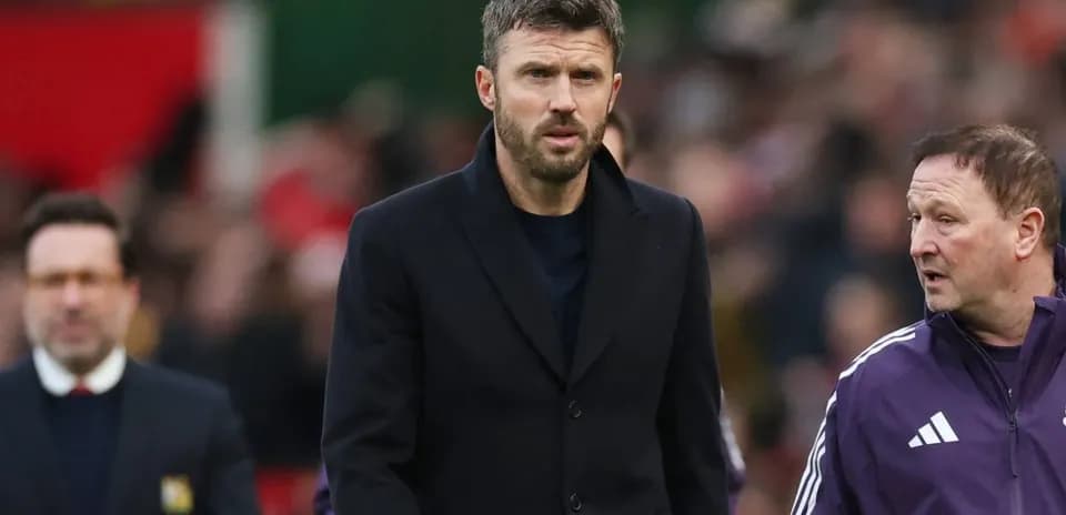 Manager walking on the pitch with coaching staff
