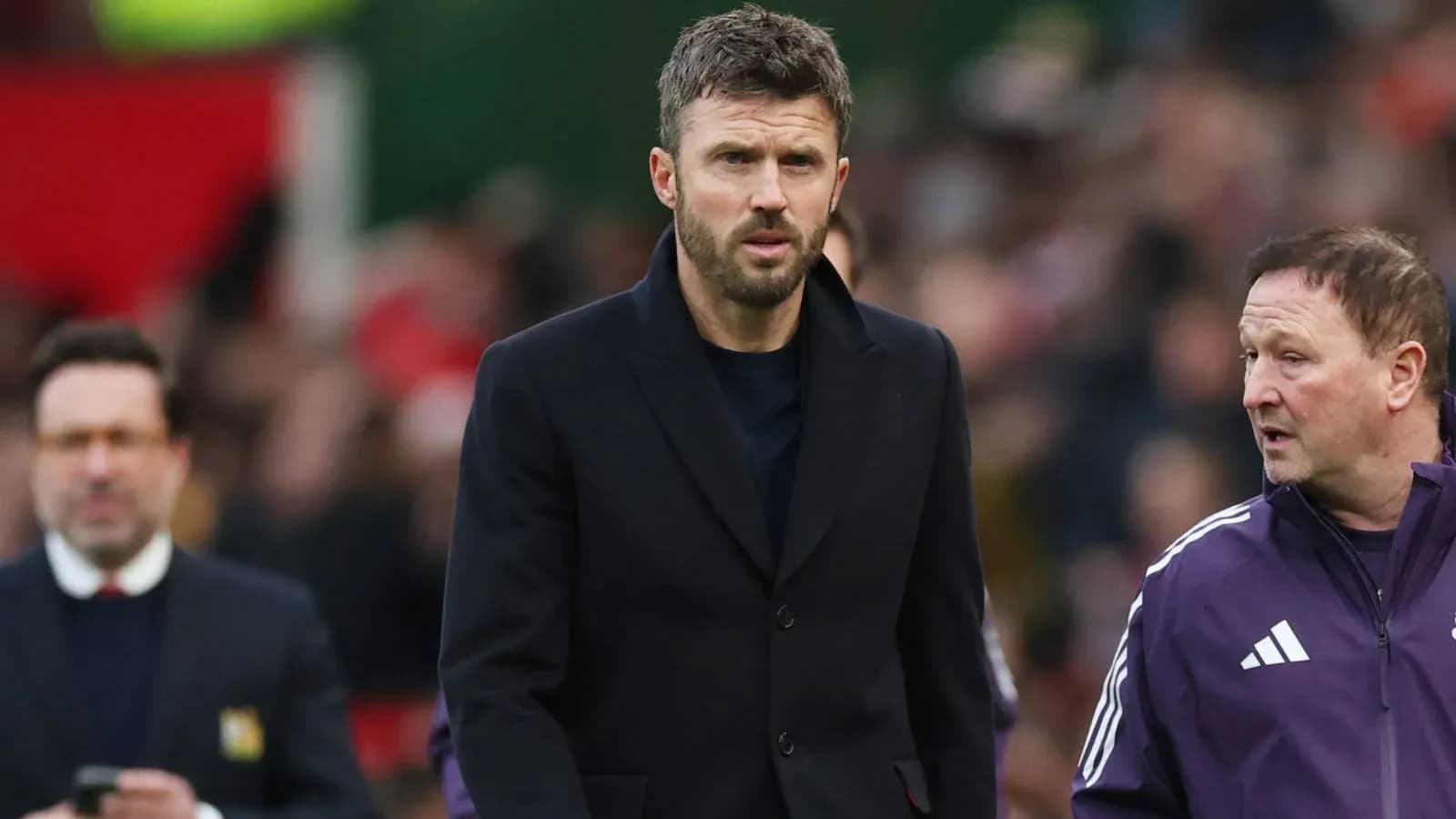 Manager walking on the pitch with coaching staff