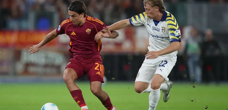 AS Roma player battling Parma opponent for the ball