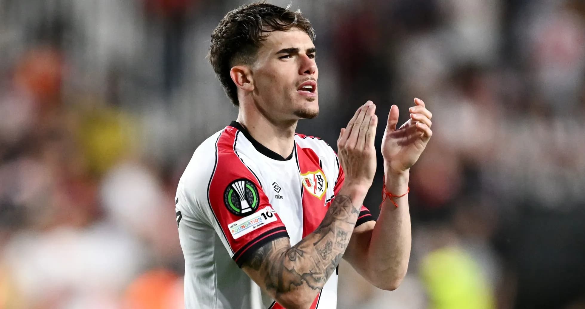 Player applauding fans after match in team jersey