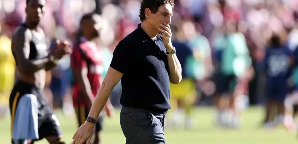 Coach walking off the field after the match