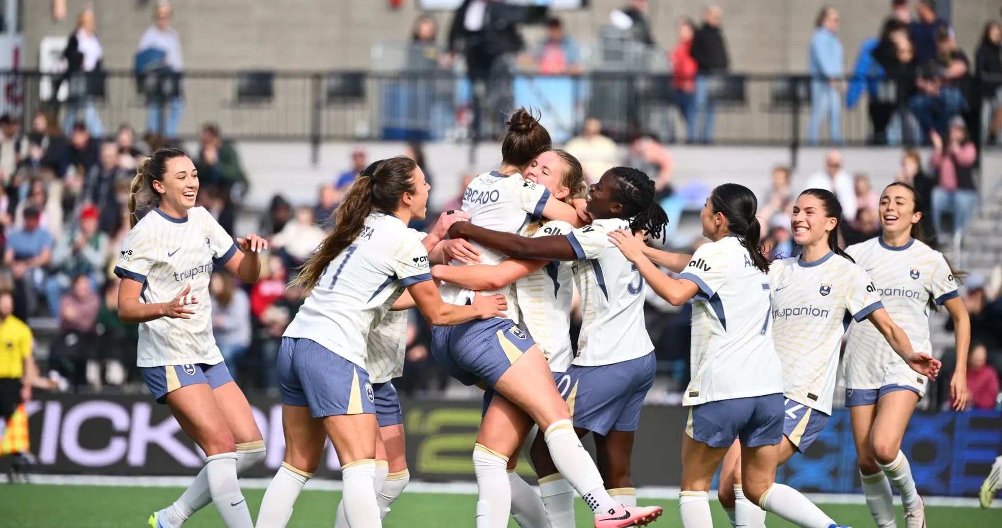 Players celebrating a goal during NWSL match