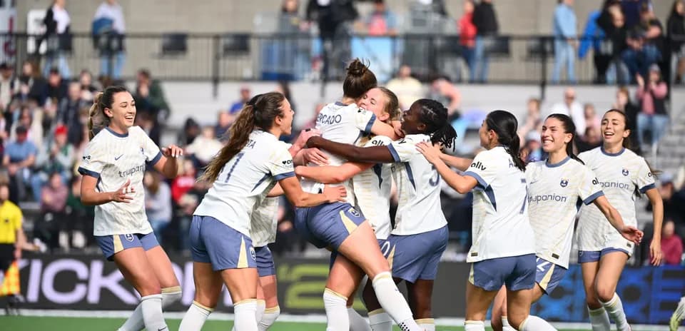 Players celebrating a goal during NWSL match
