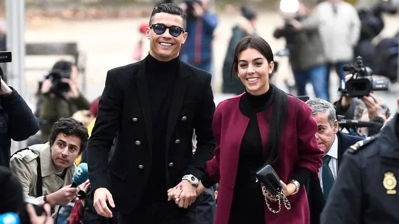Couple walking together surrounded by photographers