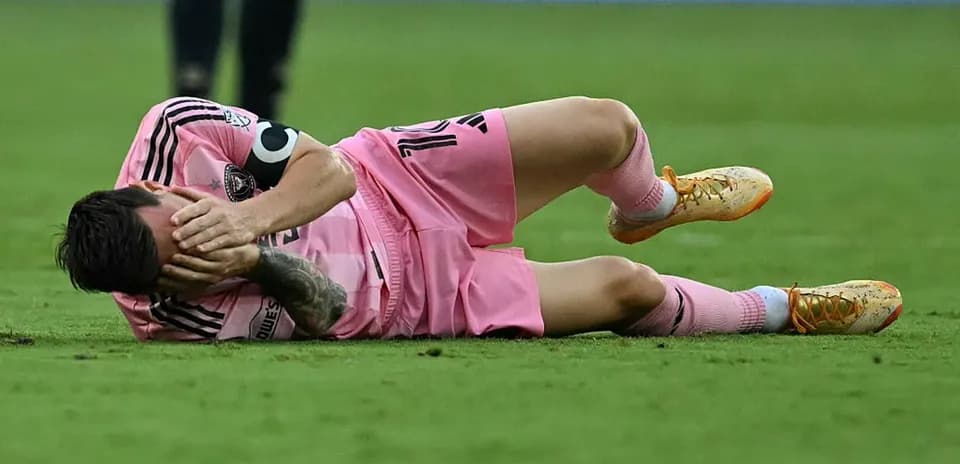 Player lying on field, holding head in distress
