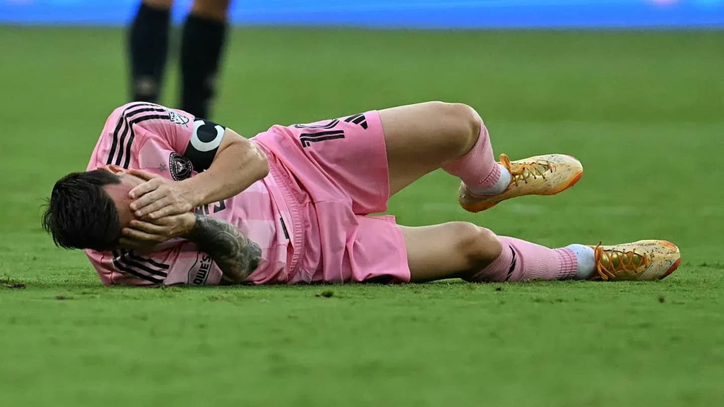 Player lying on field, holding head in distress