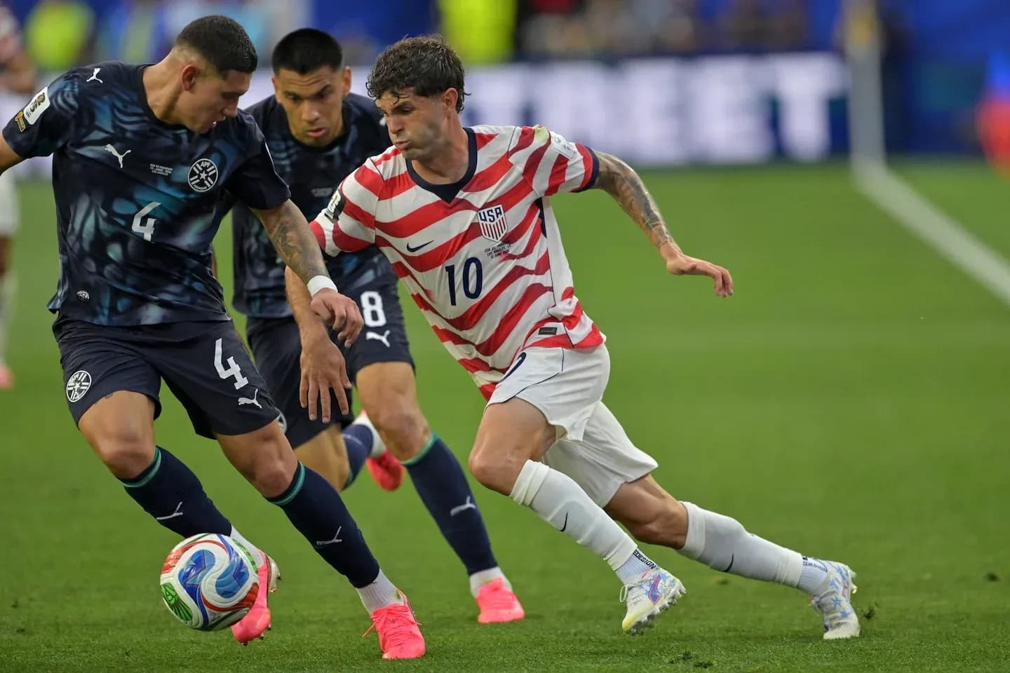 USA player dribbling past Paraguay defenders in match USA player dribbling past Paraguay defenders in match