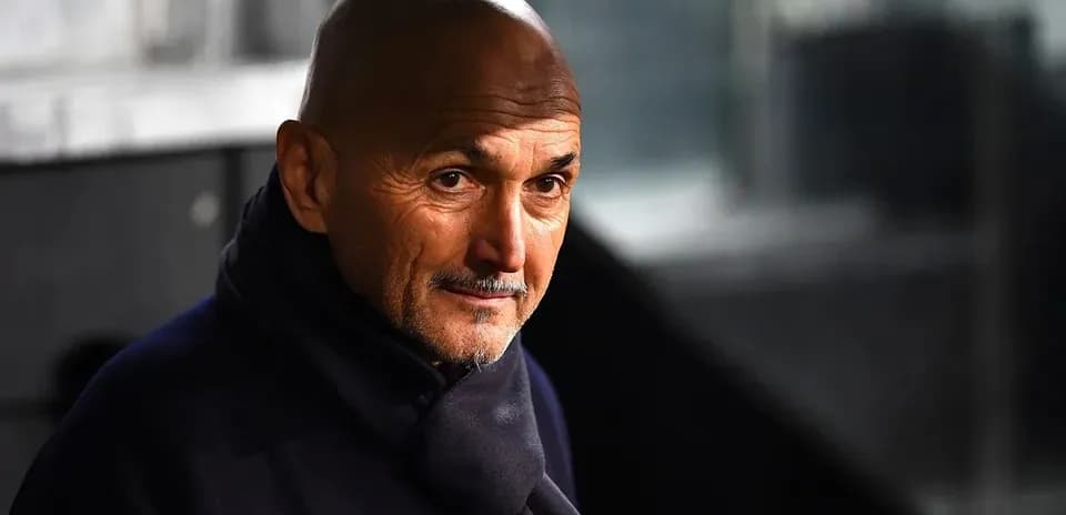 Coach wearing a dark scarf in stadium setting