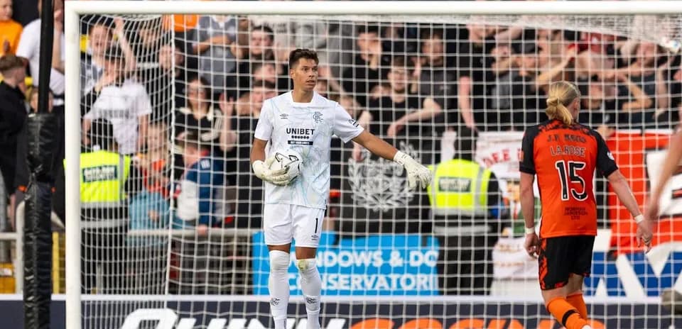 Goalkeeper in white kit gesturing during match