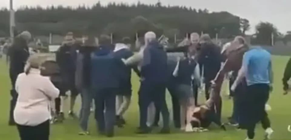 Crowd gathered around players on a sports field