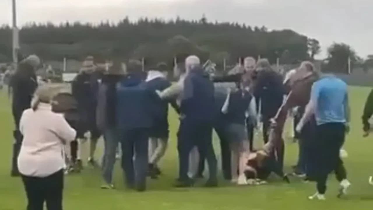 Crowd gathered around players on a sports field