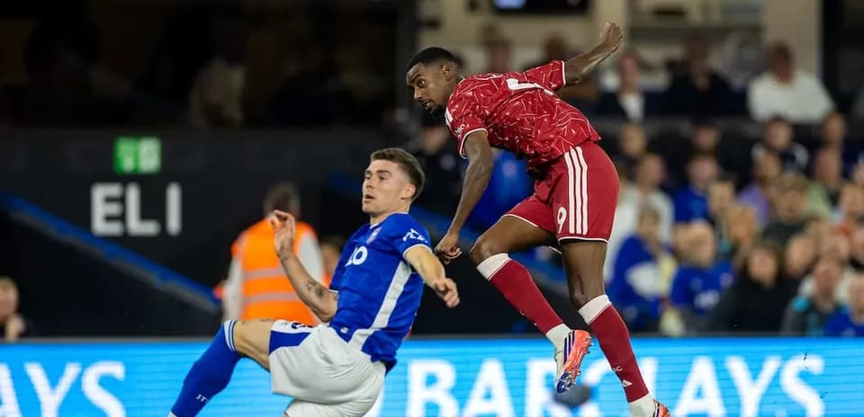Player in red evading tackle from blue player
