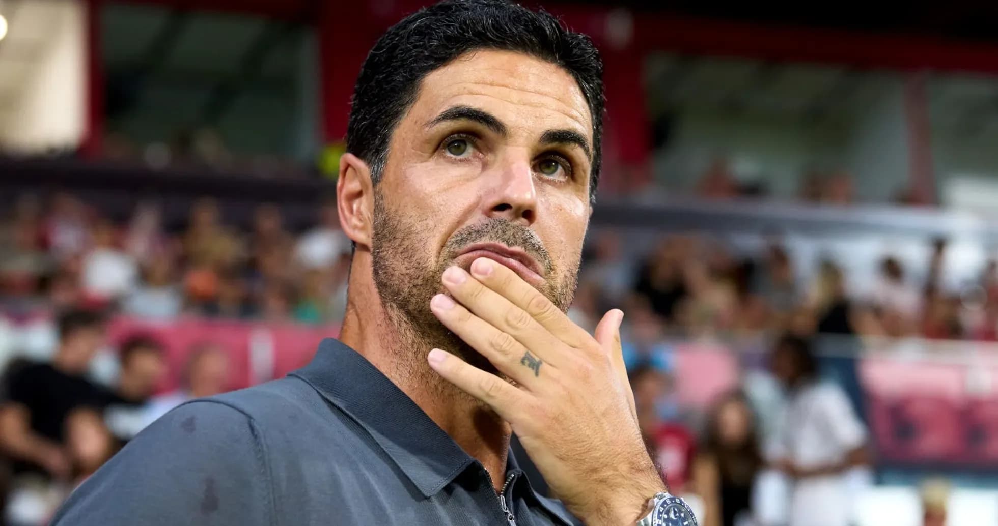 Coach observing the match with thoughtful expression