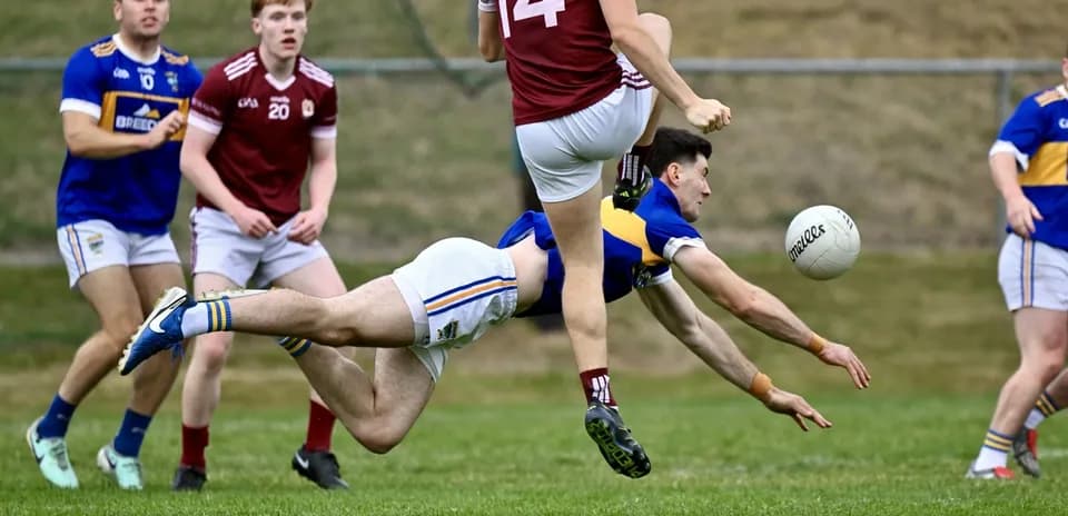 Player diving for the ball during a Gaelic football match