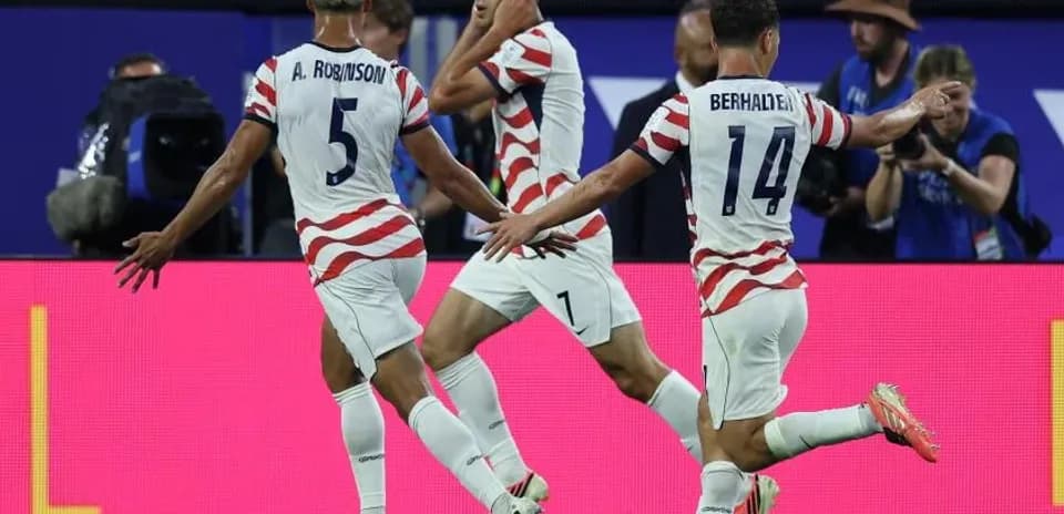 Three players celebrating a goal during match