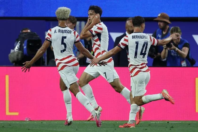 Three players celebrating a goal during match