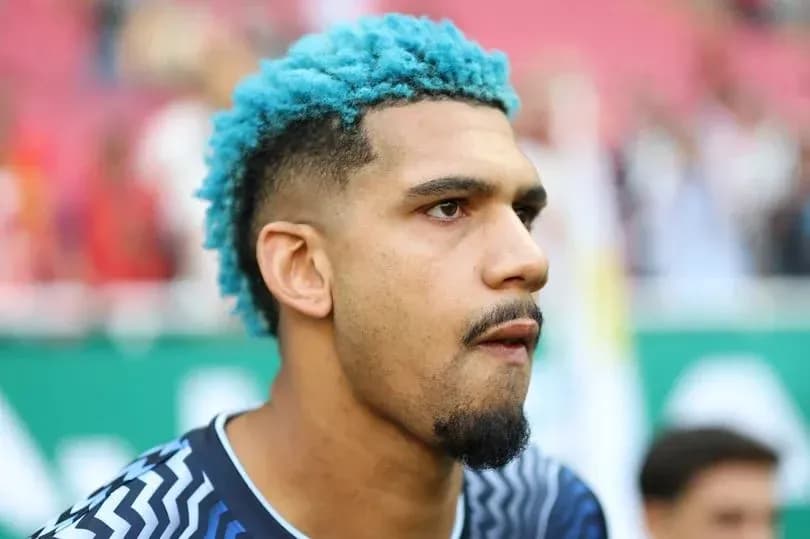 Player with blue hair in team jersey during match