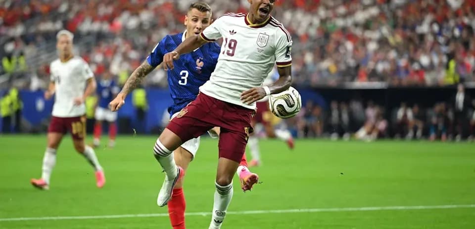 Player 19 of Spain evading tackle from French defender