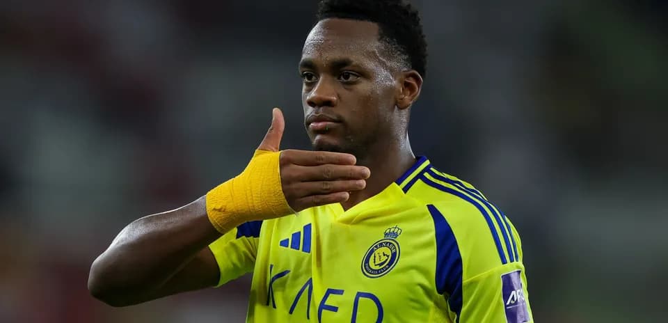Player signaling during a football match in yellow jersey