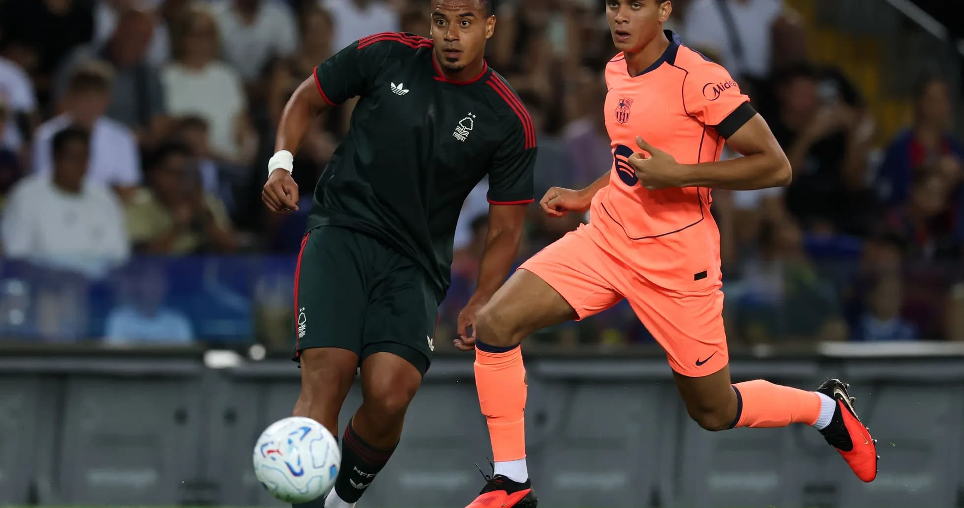 Two players running after the ball during match