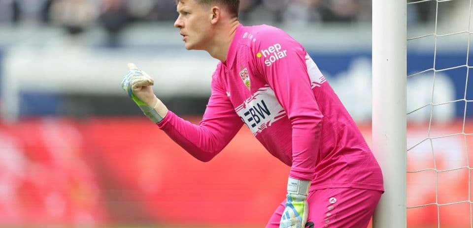 Goalkeeper in pink kit gesturing during match