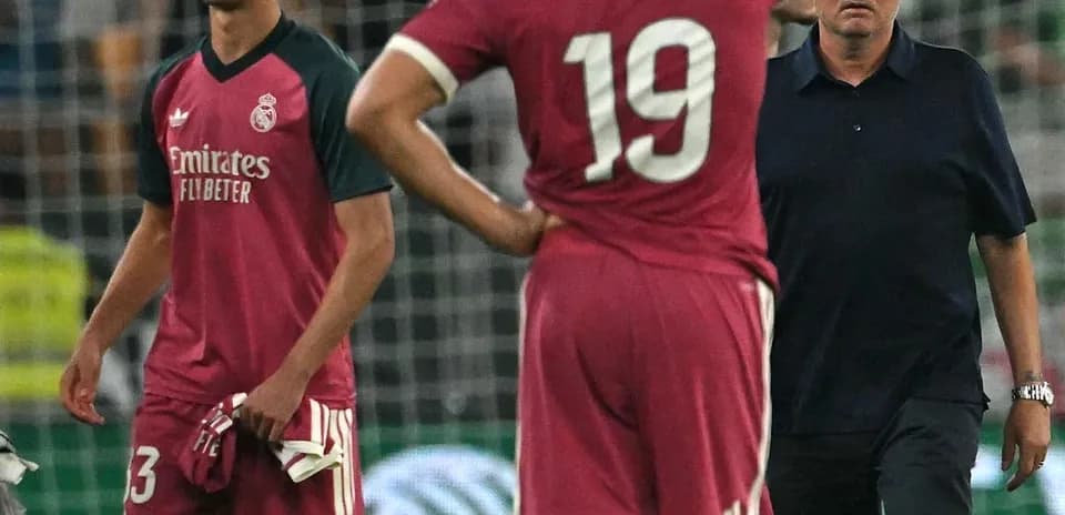 Players and coach during match, showing concern