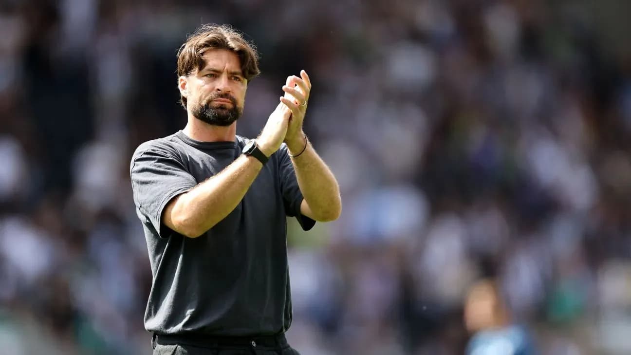 Coach applauding fans in stadium after match