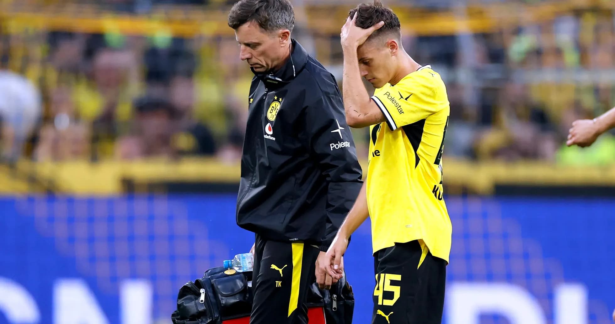 Player being assisted off the field by medical staff