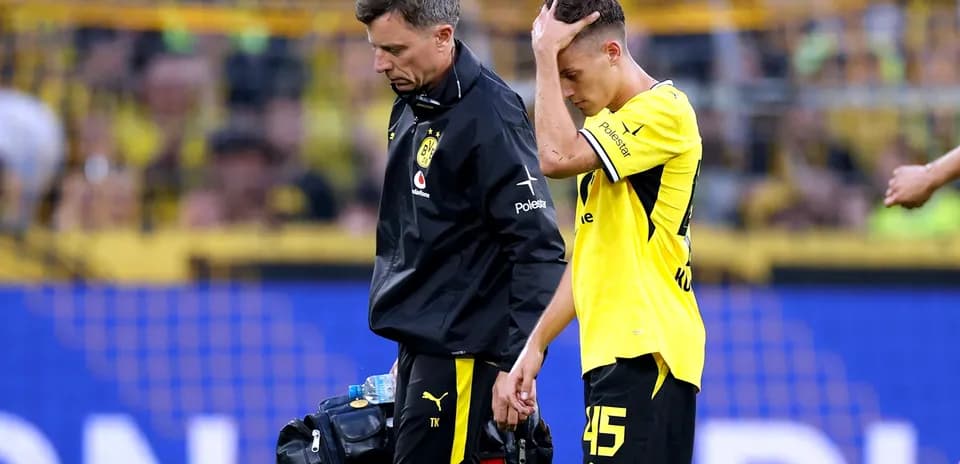 Player being assisted off the field by medical staff