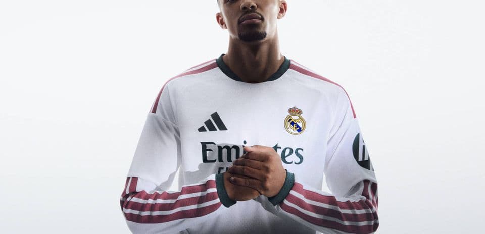 Player posing in Real Madrid jersey with logo