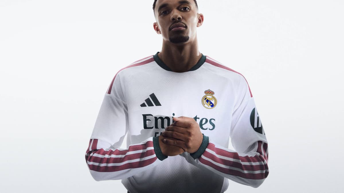 Player posing in Real Madrid jersey with logo
