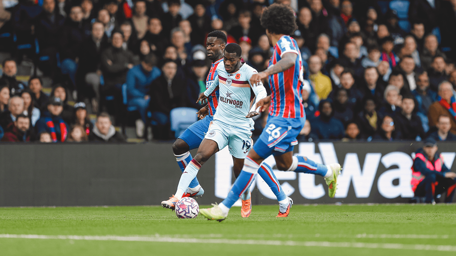 Brentford player dribbling past Crystal Palace defenders