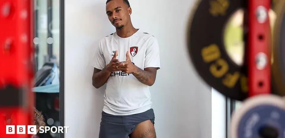 Player posing in training gear near weights