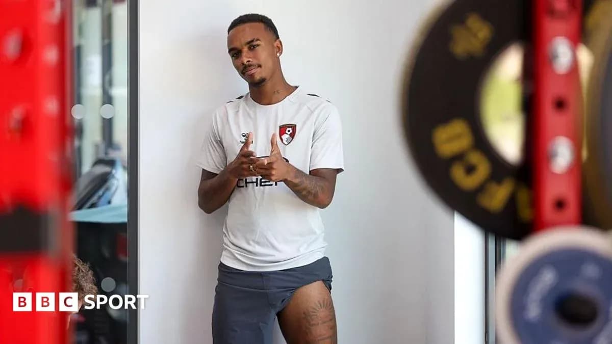 Player posing in training gear near weights