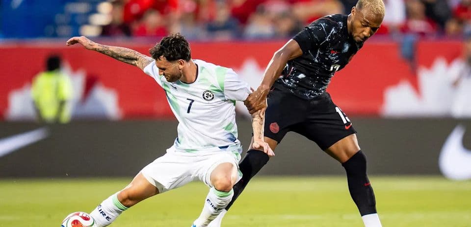 Two soccer players competing for the ball on field
