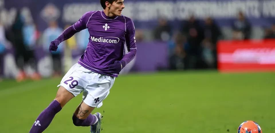 Player in purple jersey running after soccer ball