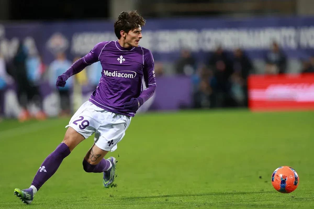 Player in purple jersey running after soccer ball