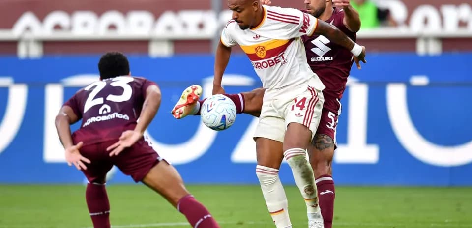 AS Roma player challenged by Torino defenders