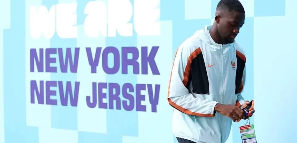 Athlete walking past 'We Are New York New Jersey' sign