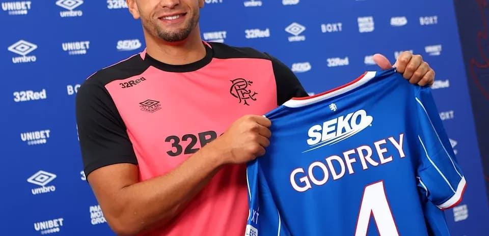 Player holding Rangers FC jersey during signing event