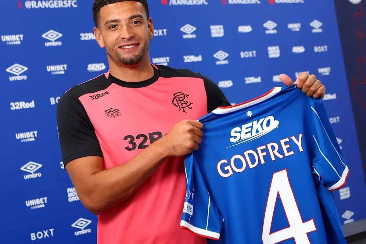 Player holding Rangers FC jersey during signing event