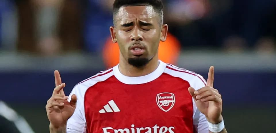Player with Arsenal jersey praying on the field