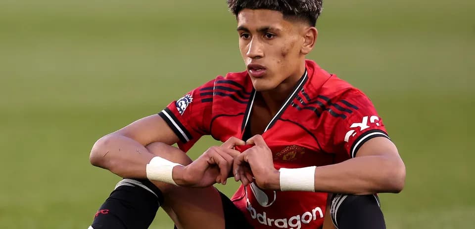 Player sitting on the pitch in Manchester United kit