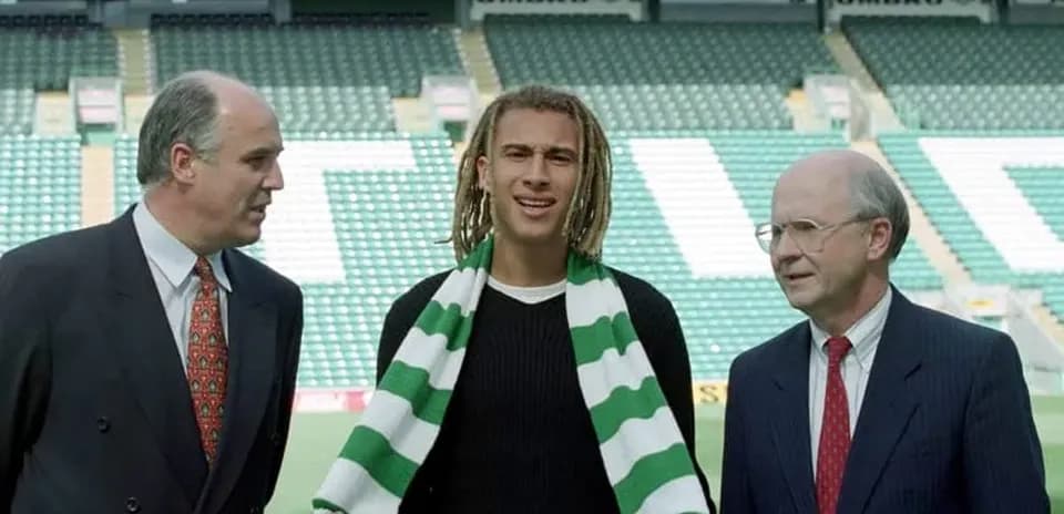 Player holding scarf with club officials at stadium