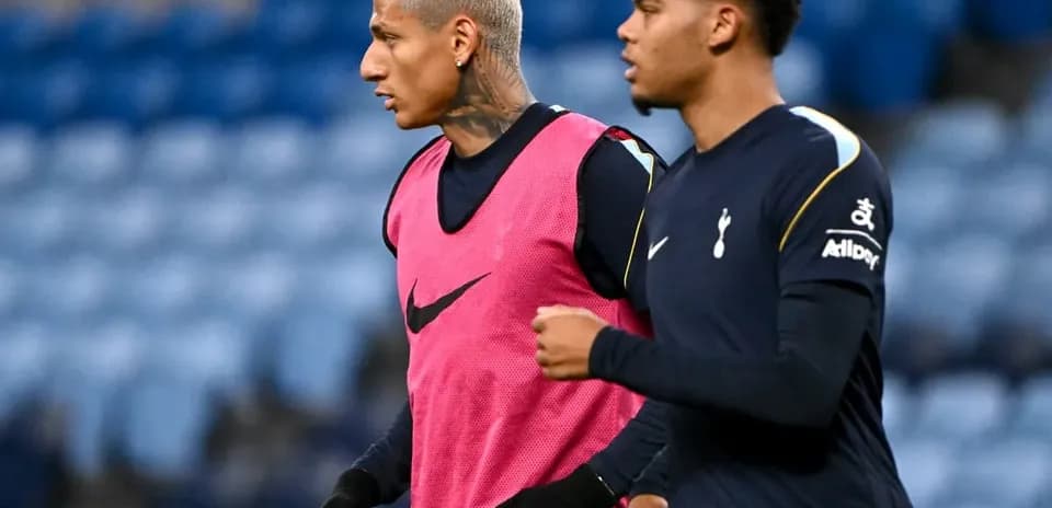 Two Tottenham players warming up on pitch