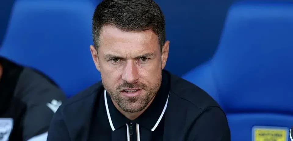 Manager seated on bench during match