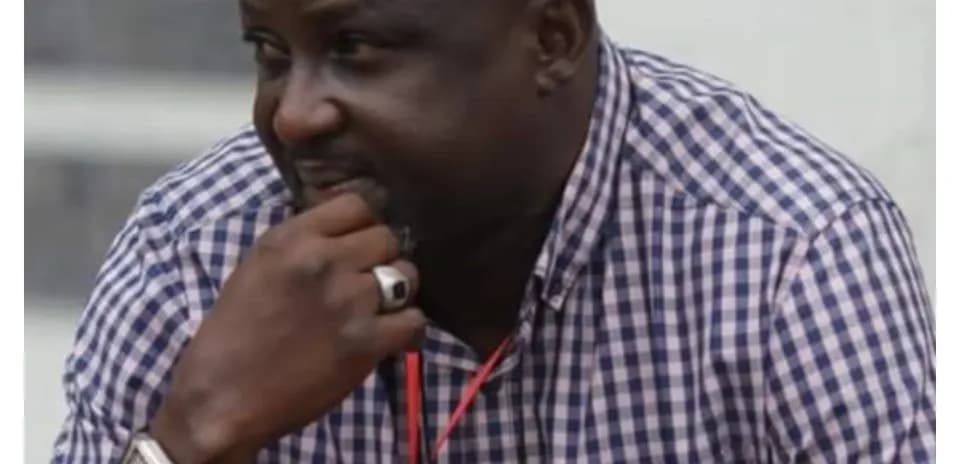 Man observing event, wearing a checkered shirt