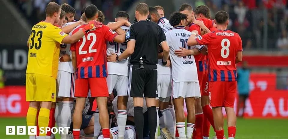 Players from both teams huddled around an injured player