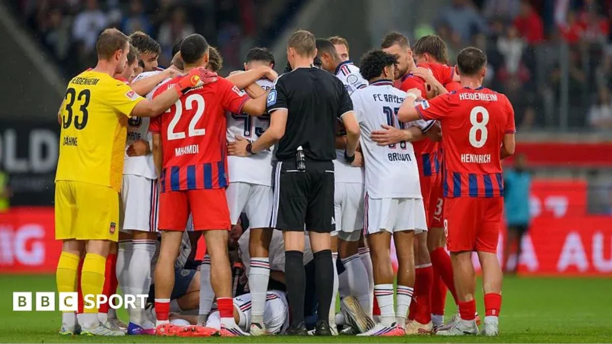 Players from both teams huddled around an injured player
