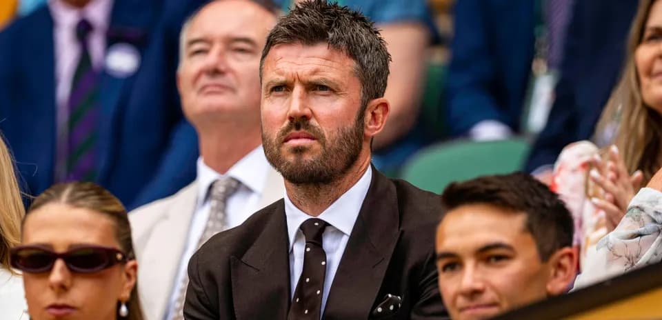 Man in suit watching tennis match in crowd